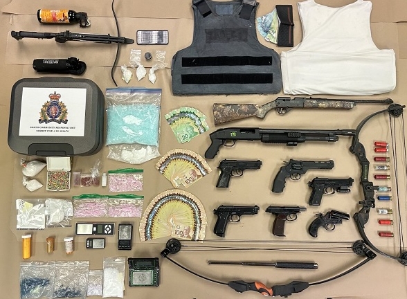 Drugs, cash and loaded weapons seized from a house by Surrey police, eight arrested